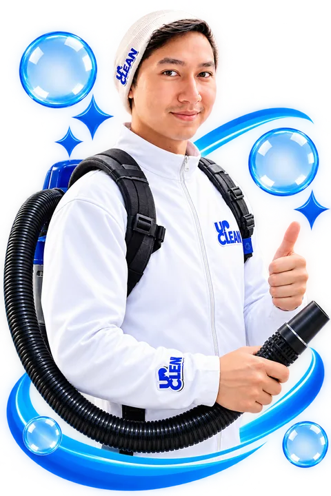UpClean commercial cleaning team member in a white UpClean jacket with a backpack vacuum, giving a thumbs up, serving Kelowna and the Okanagan